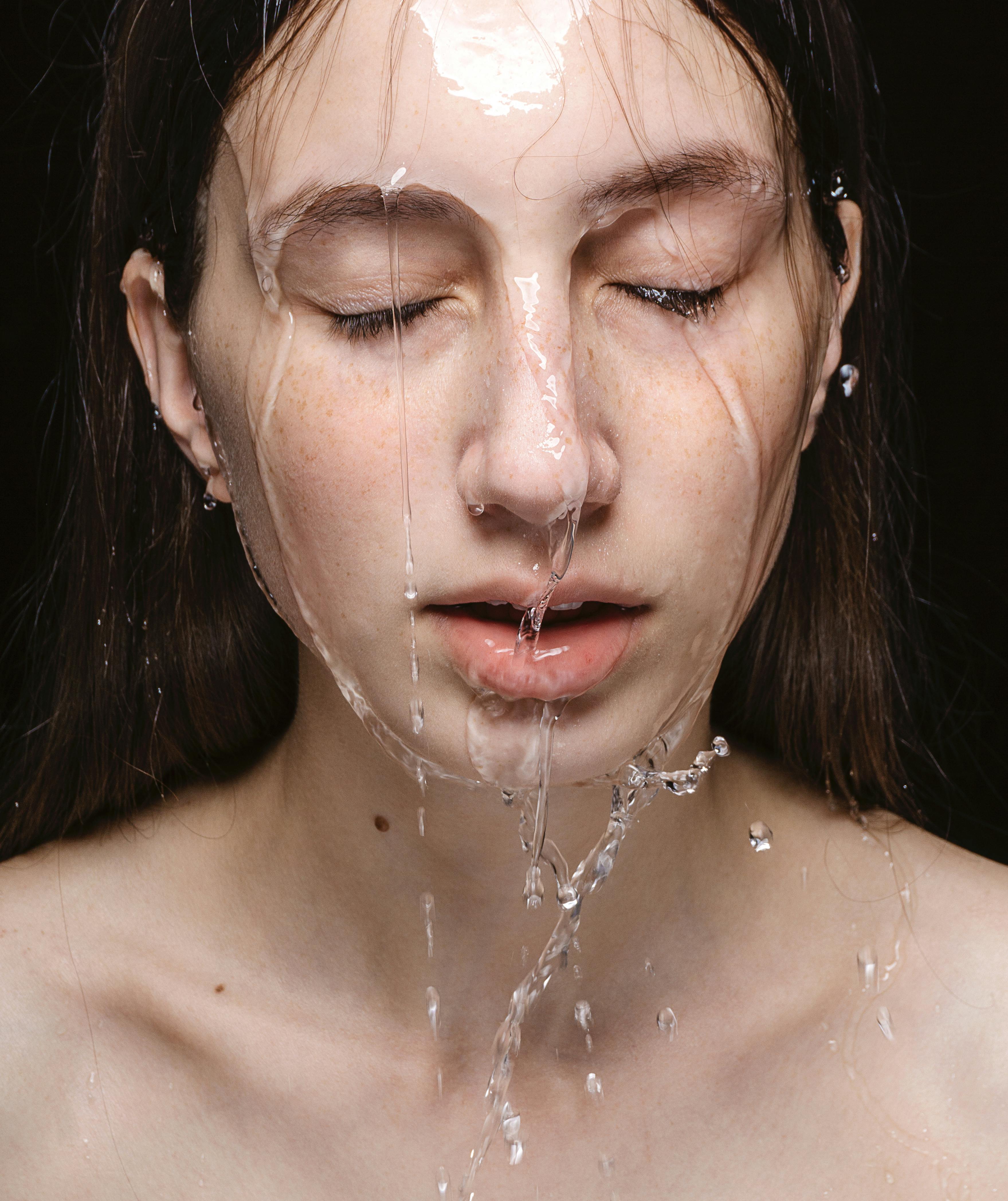 A girl with water washing down her face