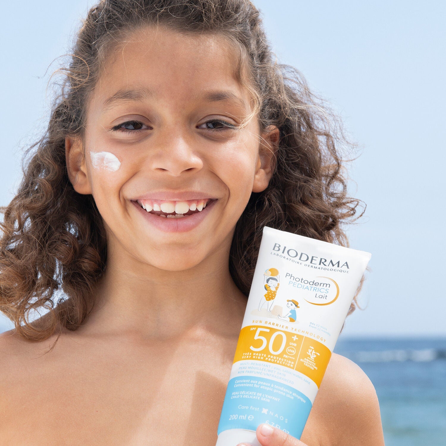 A girl holding Bioderma Sunscreen for Children/ Pediatrics Lait