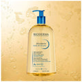 Bioderma Atoderm shower oil bottle with pump on a yellow background