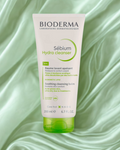 Bioderma Sébium Hydra Cleanser tube on a green fabric background
