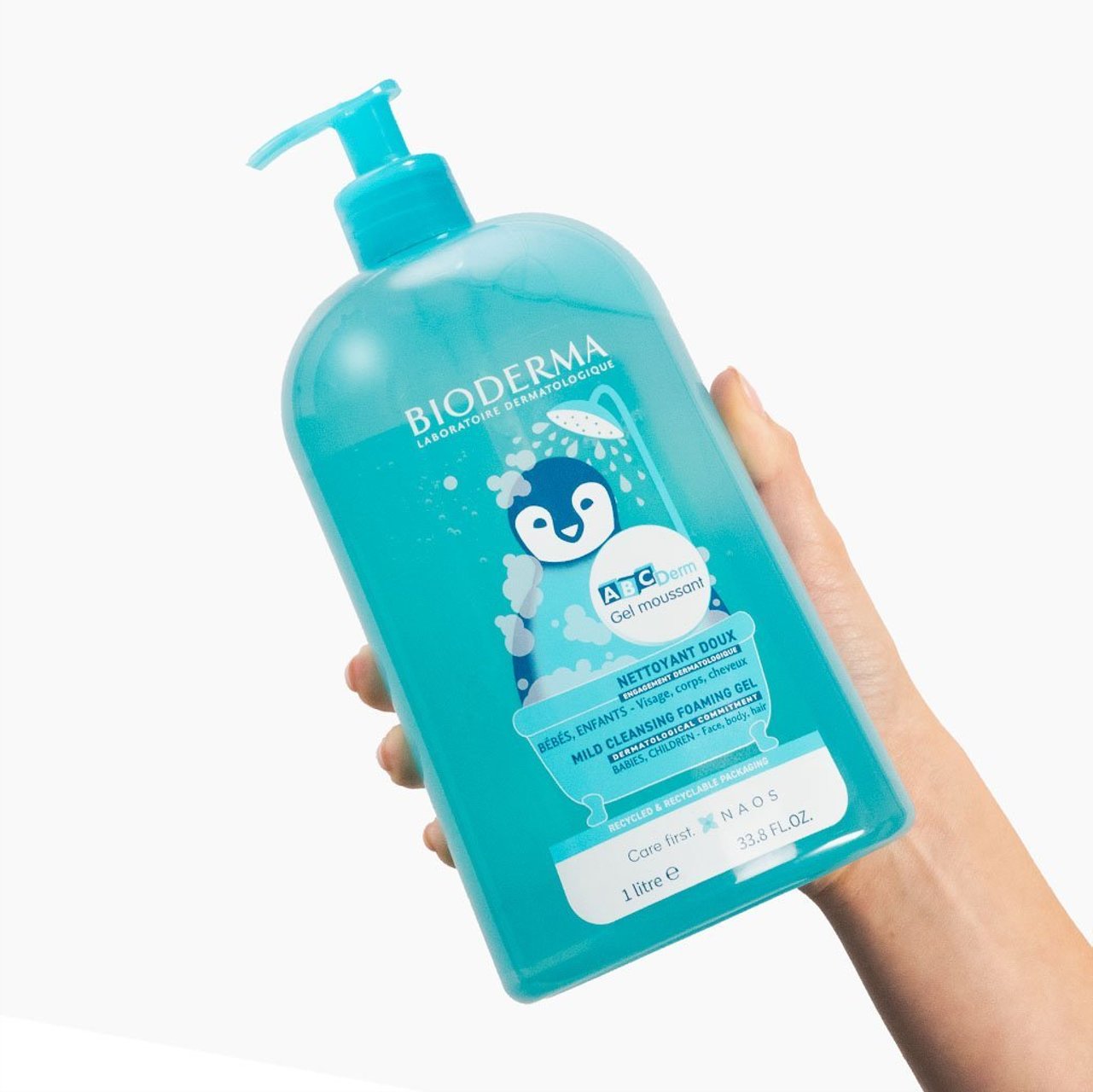 Bioderma bottle held by a hand on a white background